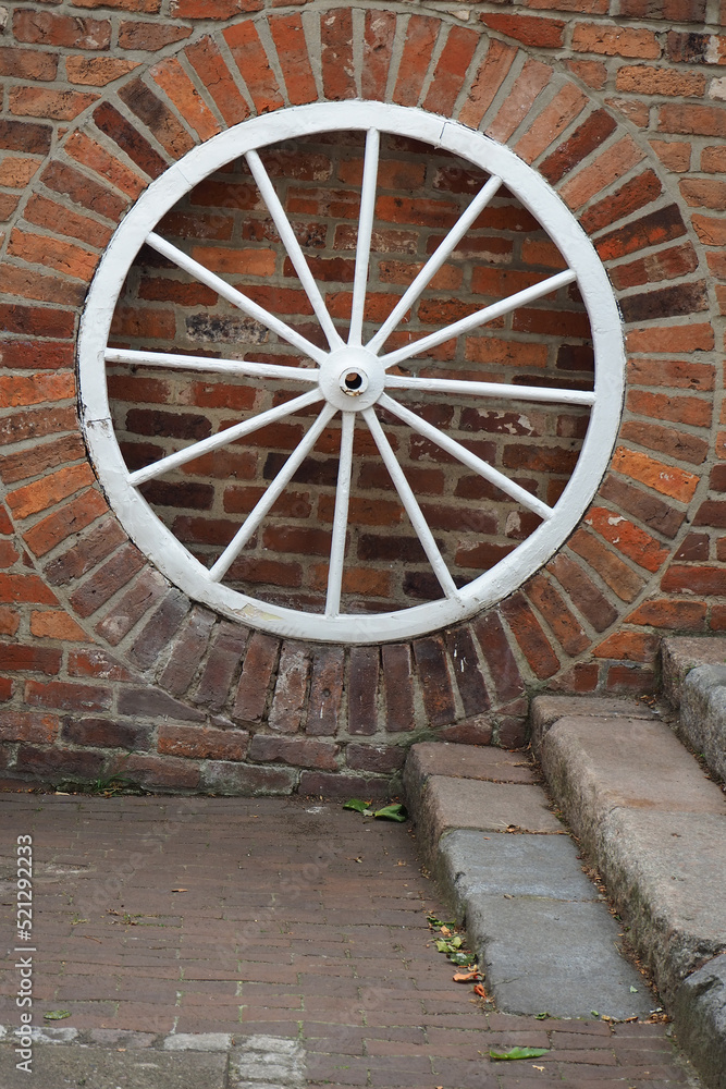 texture background of brick wall and old carriage wheel painted white with copy space texture background of brick wall and old carriage wheel painted white with copy space