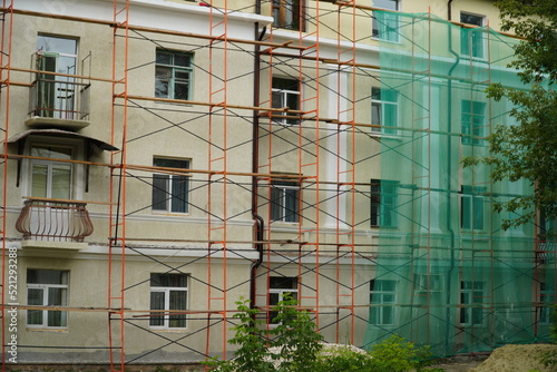 Facade under construction with scaffolding and protective net