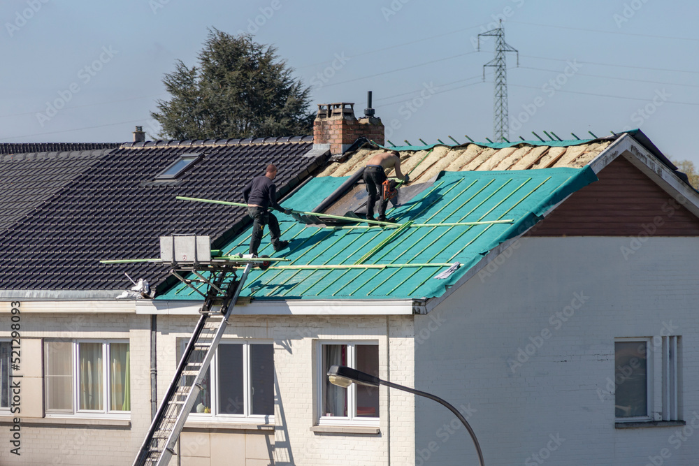 Ouvriers travaillant à l'isolation d'un toit - obrazy, fototapety, plakaty 