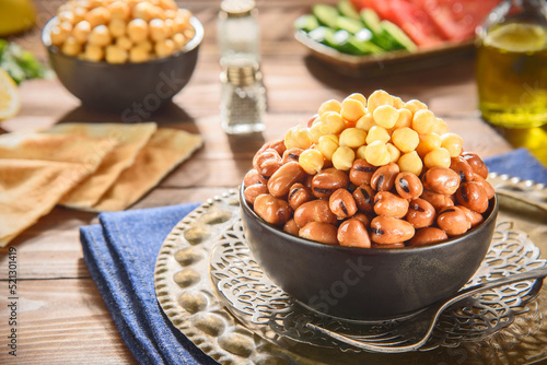 Arabic Cuisine: Egyptian traditional dish "Ful medames". Middle Eastern breakfast with cooked fava beans and delicious chickpeas. Close up with copy space.