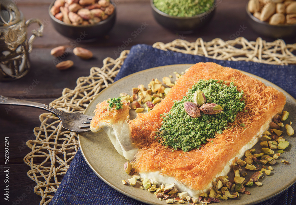 Arabic Cuisine; Traditional Middle Eastern Cheese Kunafa Dessert. A delicious pastry consisting of soft melty cheese and shredded phyllo dough. Served with sugar syrup and crushed pistachio. Arabic Cuisine; Traditional Middle Eastern Cheese Kunafa Dessert. A delicious pastry consisting of soft melty cheese and shredded phyllo dough. Served with sugar syrup and crushed pistachio.