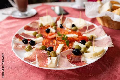 plate with garnished ham, salami, cheese and olives