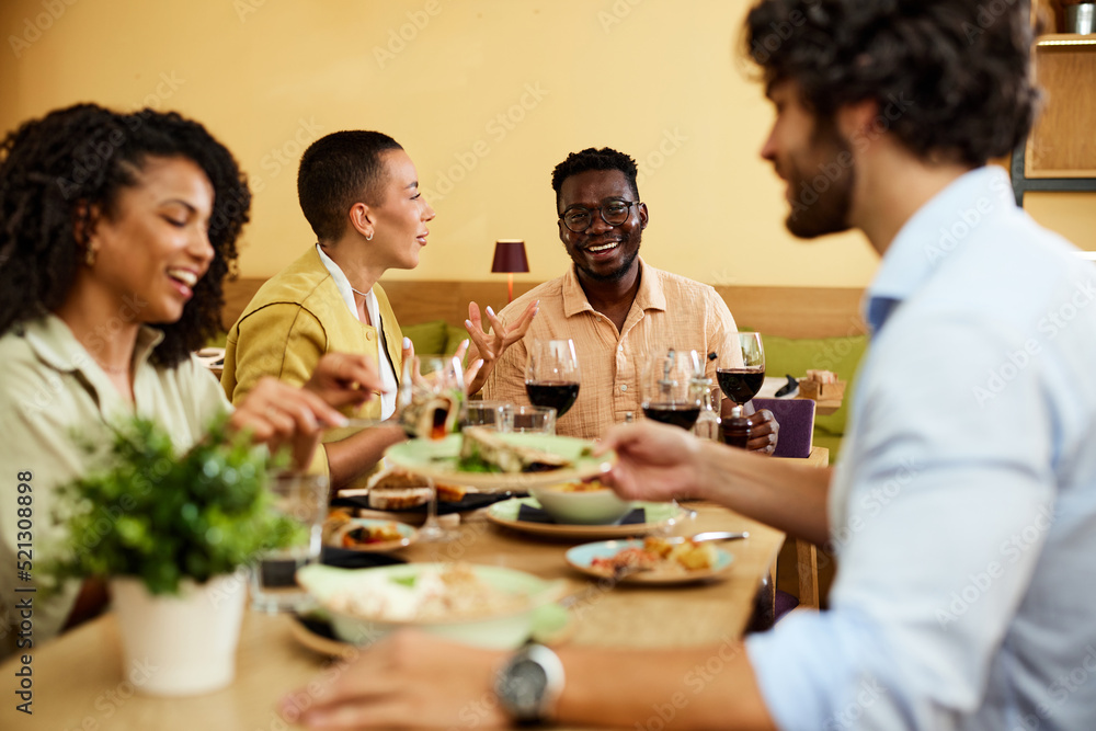 Cheerful friends sit at the dinner table in a restaurant, eat food and have fun. Cheerful friends sit at the dinner table in a restaurant, eat food and have fun.