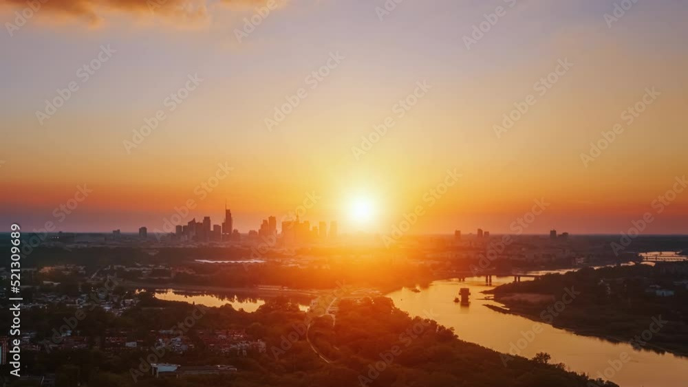 Aerial time lapse hyperlapse beautiful sunset over modern city, golden hour cityscape, skyline. Warsaw city panorama and Vistula river lit with warm evening sun light. Drone shot, urban scene Aerial time lapse hyperlapse beautiful sunset over modern city, golden hour cityscape, skyline. Warsaw city panorama and Vistula river lit with warm evening sun light. Drone shot, urban scene