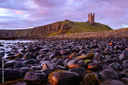 Dunstanburgh Castle was built by Earl Thomas of Lancaster between 1313 and 1322. Placed on the coast of Northumberland in northern England, between the villages of Craster and Embleton. photo