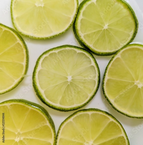 Green lemon slices composition in white