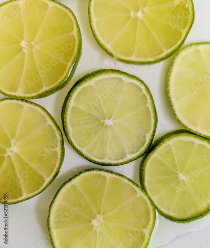 Green lemon slices composition in white