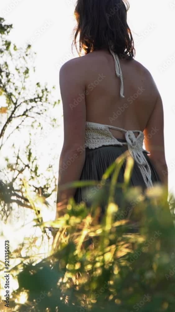 Back view of a female walking in a skirt and white top