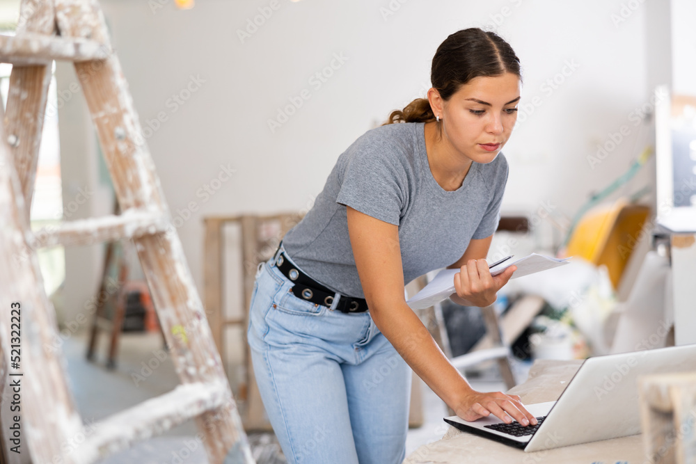 Owner of the cottage checks the completion of repair work using a laptop