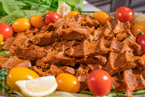 Çiğ Köfte (Raw Meatballs) is made with bulgur, ground meat, tomato paste, pepper paste, pomegranate syrup, and lots of spices. It is made by mixing the all ingredients photo