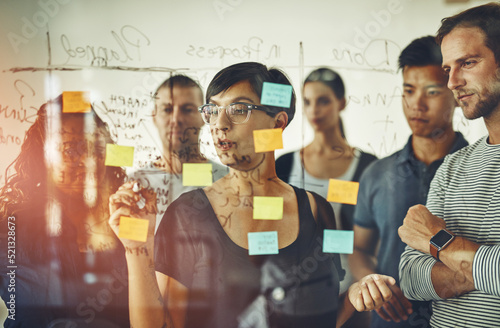 Obraz na plátně Business people planning ideas on a glass board thinking, brainstorming and working on strategy for a project