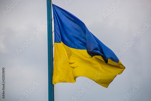 Flag of Ukraine on a flagpole against a gray sky