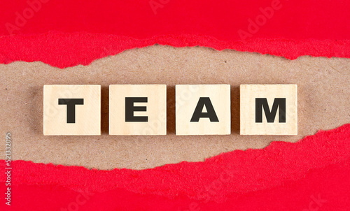 TEAM word on wooden cubes on red torn paper , financial concept background