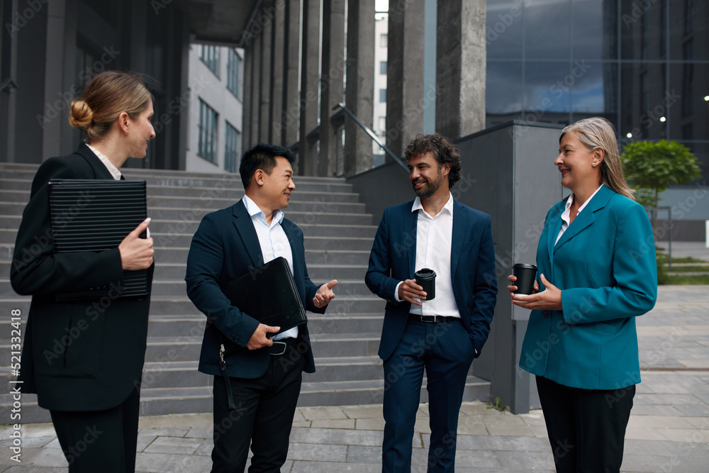 Business People Having Conversation Near Office On Street. Beautiful Smiling Coworkers With Coffee Near Building. Business and Corporate Lifestyle Concept Business People Having Conversation Near Office On Street. Beautiful Smiling Coworkers With Coffee Near Building. Business and Corporate Lifestyle Concept