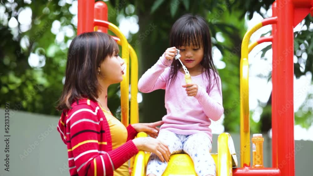 Cute little girl play soap bubbles with her mother Cute little girl play soap bubbles with her mother