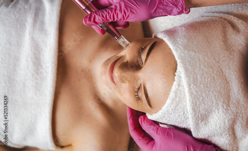 Obraz na plátně Woman getting a facial dermapen treatment at spa salon
