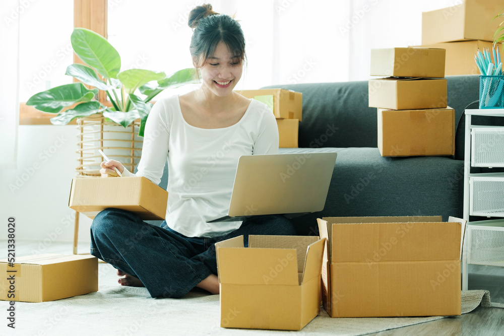 Online small business owner writing address on parcel box. Online small business owner writing address on parcel box.