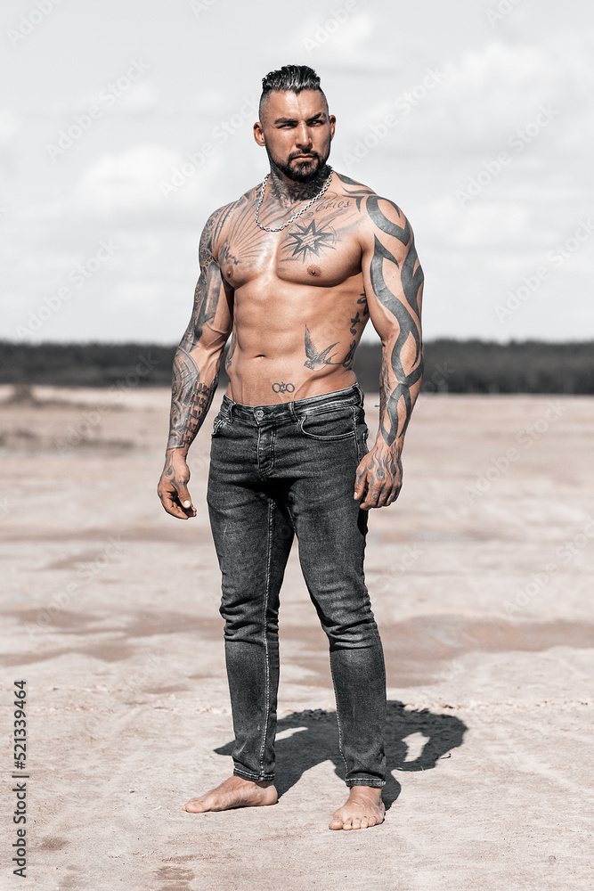 Sexy portrait of muscular handsome topless male model at the beach