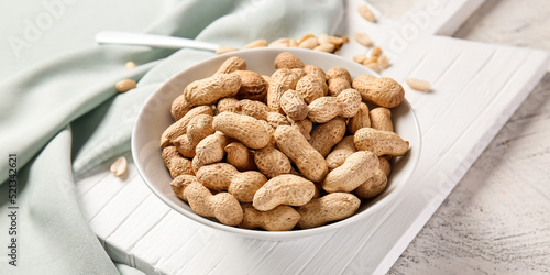 Bowl with peanuts on table,...