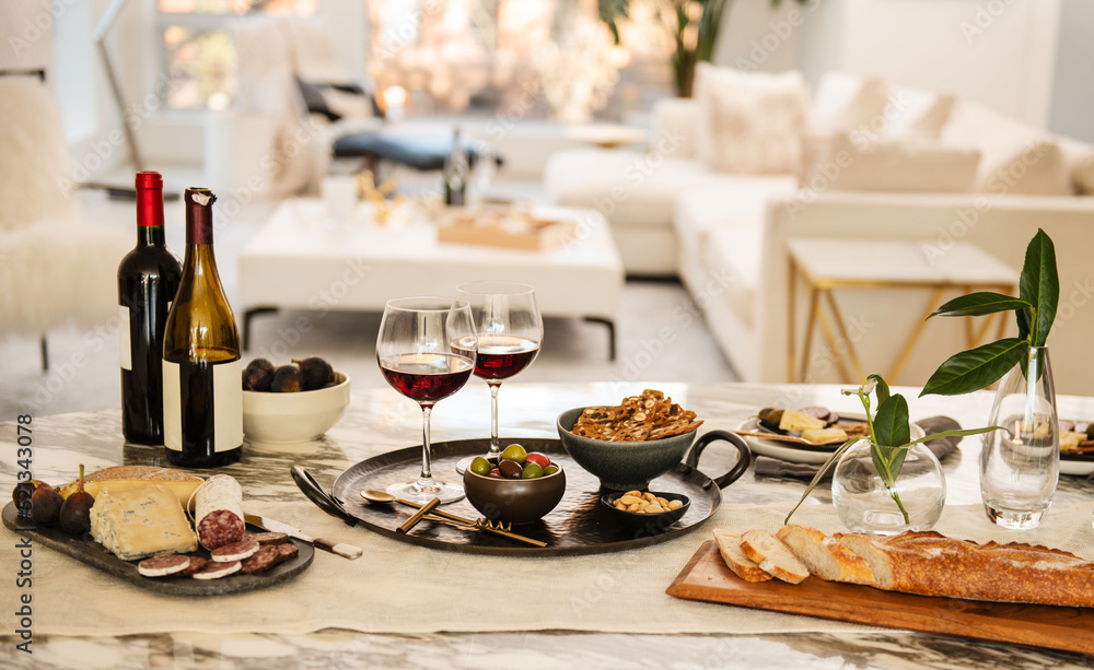 table setting with appetizers of gourmet cheese, salami, figs, olives, crackers, bread and red wine table setting with appetizers of gourmet cheese, salami, figs, olives, crackers, bread and red wine