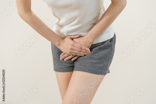 Vaginal, urinary incontinence. Pain asian young woman hand holding crotch suffering from pain ,itchy or scratch of vagina, genital itching from infection. Gynecological problems menstrual disorder