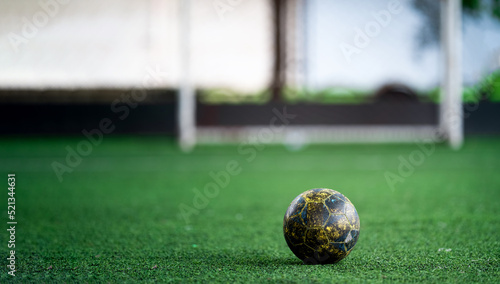 Experienced soccer ball is placed on a grass field. We can only imagine how long this ball has been used in training by professional athletes. photo