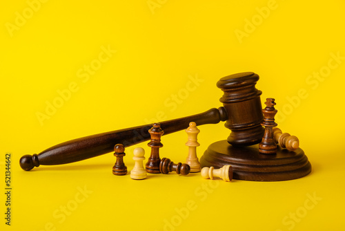 Judge gavel and chess pieces on color background