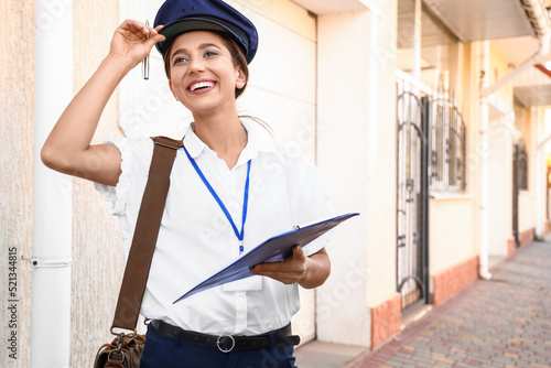 Young postwoman with clipbo...