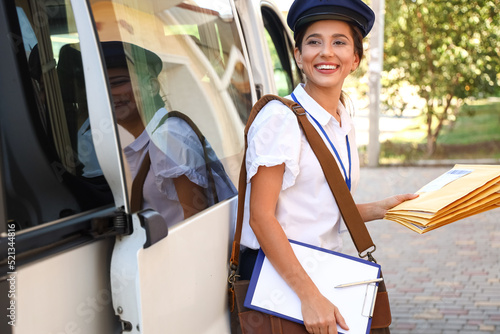 Young postwoman with clipbo...