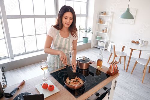 Young Asian woman frying ri...