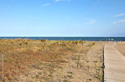 wooden walkway for pedestrians leading down to the beach by the sea without people