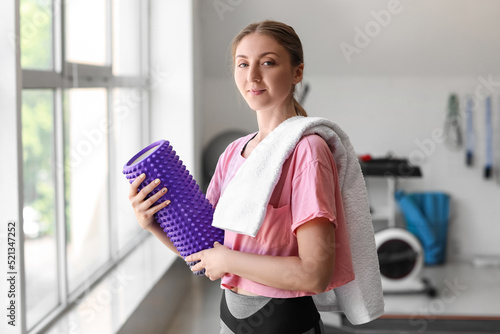 Young woman with foam rolle...