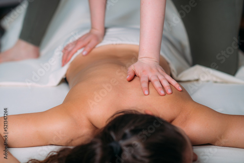 Back massage in a massage salon, woman having a relaxing back massage.