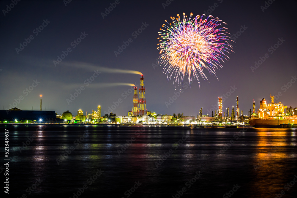 堺泉北臨海工業地帯の夜景と停泊中の船の傍に打ちあがる花火。合成写真