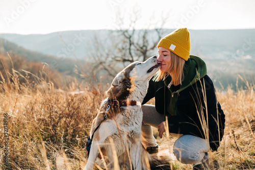 Young woman and her husky dog trek down a forest trail offering a scenic view of the trees changing colors. Fit girl takes her miniature pinscher for a walk in woods