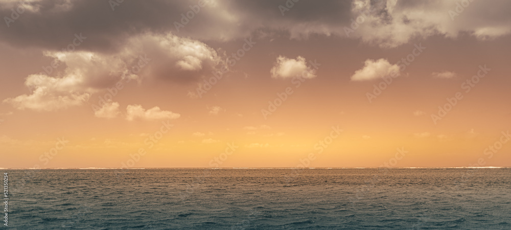 Dramatic ocean sunset sky with clouds. Colorful sunrise over the sea.
