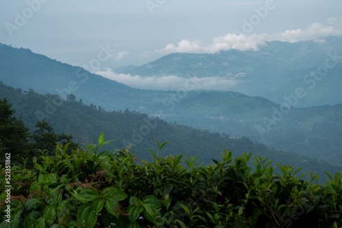 View from Kurseong in morning time. Mountain range with visible silhouettes through the morning colorful fog. The sea of ​​mist in the morning when viewed from Kurseong, West Bengal, India. photo