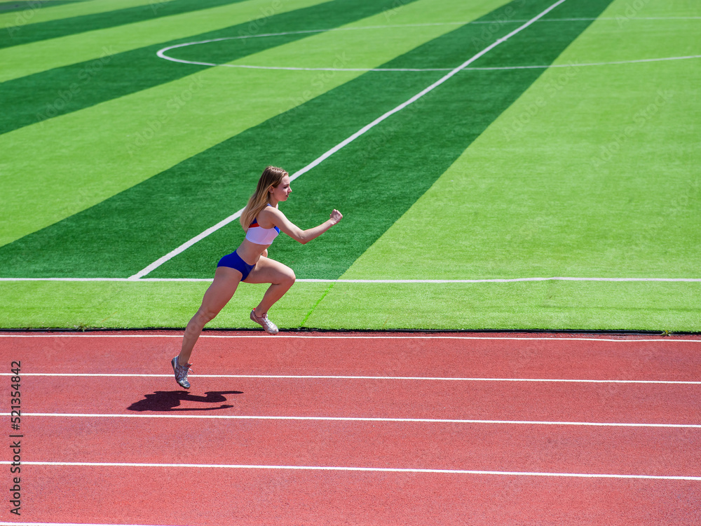 Young caucasian woman is engaged in jogging at the stadium outdoors.