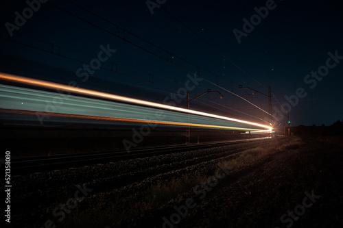 Luminous paths created at night by a passenger train.