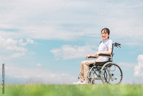車椅子に座る笑顔の日本人女性（青空） 