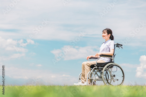 車椅子に座る笑顔の日本人女性（青空） 