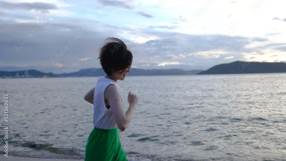 夕暮れの海を散策する女性