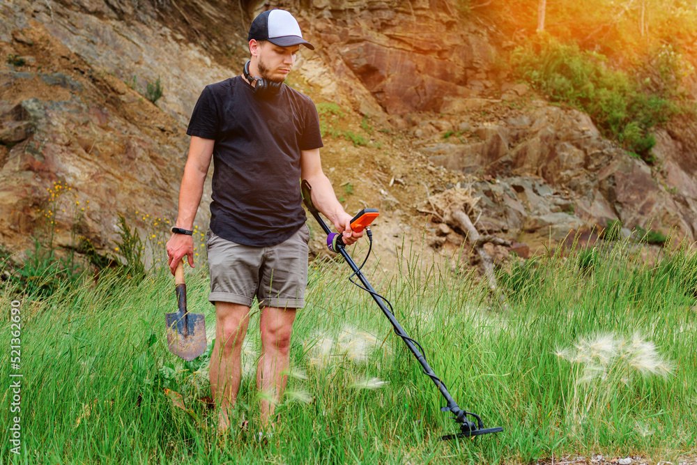 metal detector at work in the forest or field. Search for treasure and ...