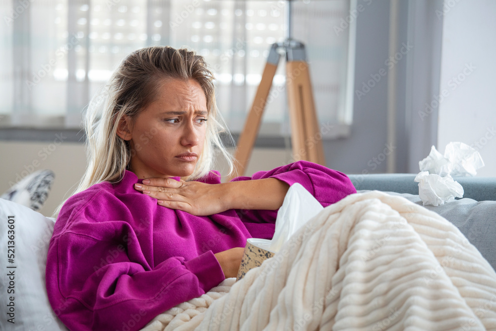 Sick woman with headache sitting under the blanket. Sick woman with