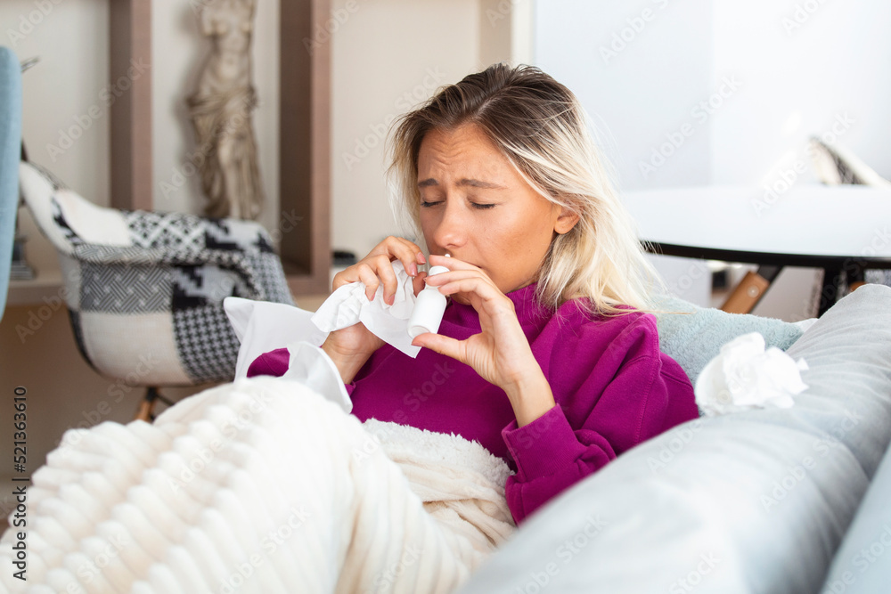 Woman is having flu and she is using nasal spray to help herself. Woman using nasal spray. Nasal