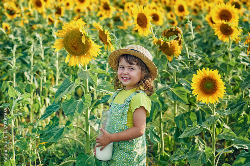 Happy little girl in a field with sunflowers.