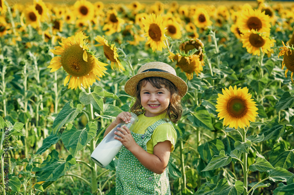 Happy little girl in a field with sunflowers.
