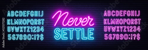 Never Settle neon quote on a brick wall.