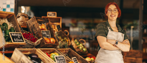 Fotografie, Obraz Happy supermarket owner smiling at the camera in her shop