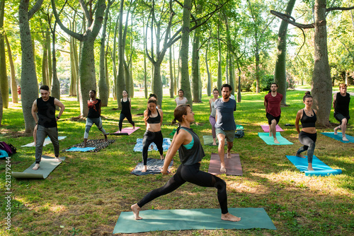 yoga teacher teaching a group of people at the park